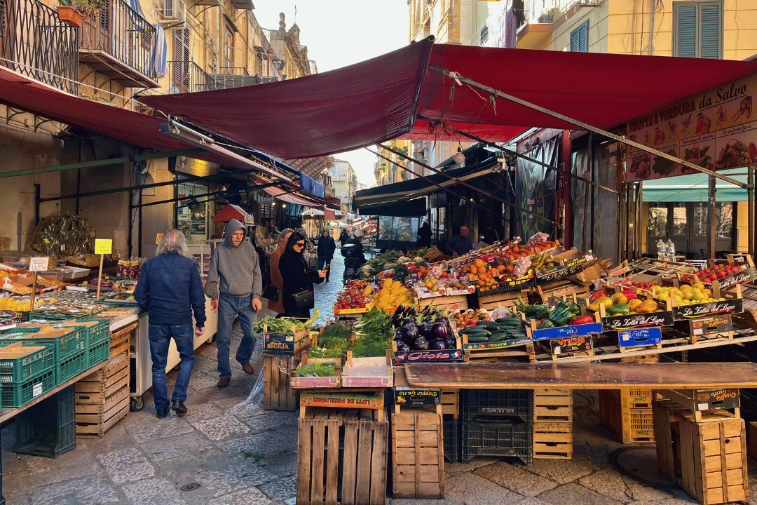 Marktstände mit Obst und Gemüse in einer Straße in Palermo