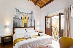 Ein Zimmer mit Bett und geöffnetem Fenster im Hotel Palermo Quattro Canti