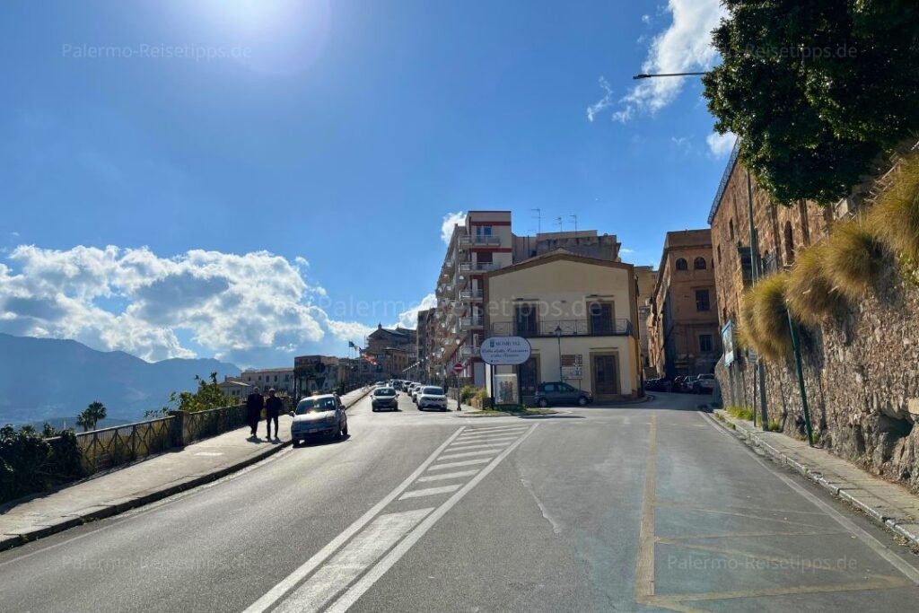 Straße mit Steigung und Gebäude unter blauem Himmel