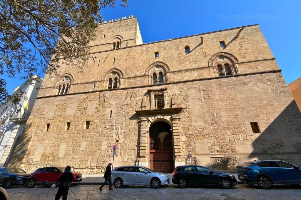 Autos vor einem steinernen Palast in Palermo
